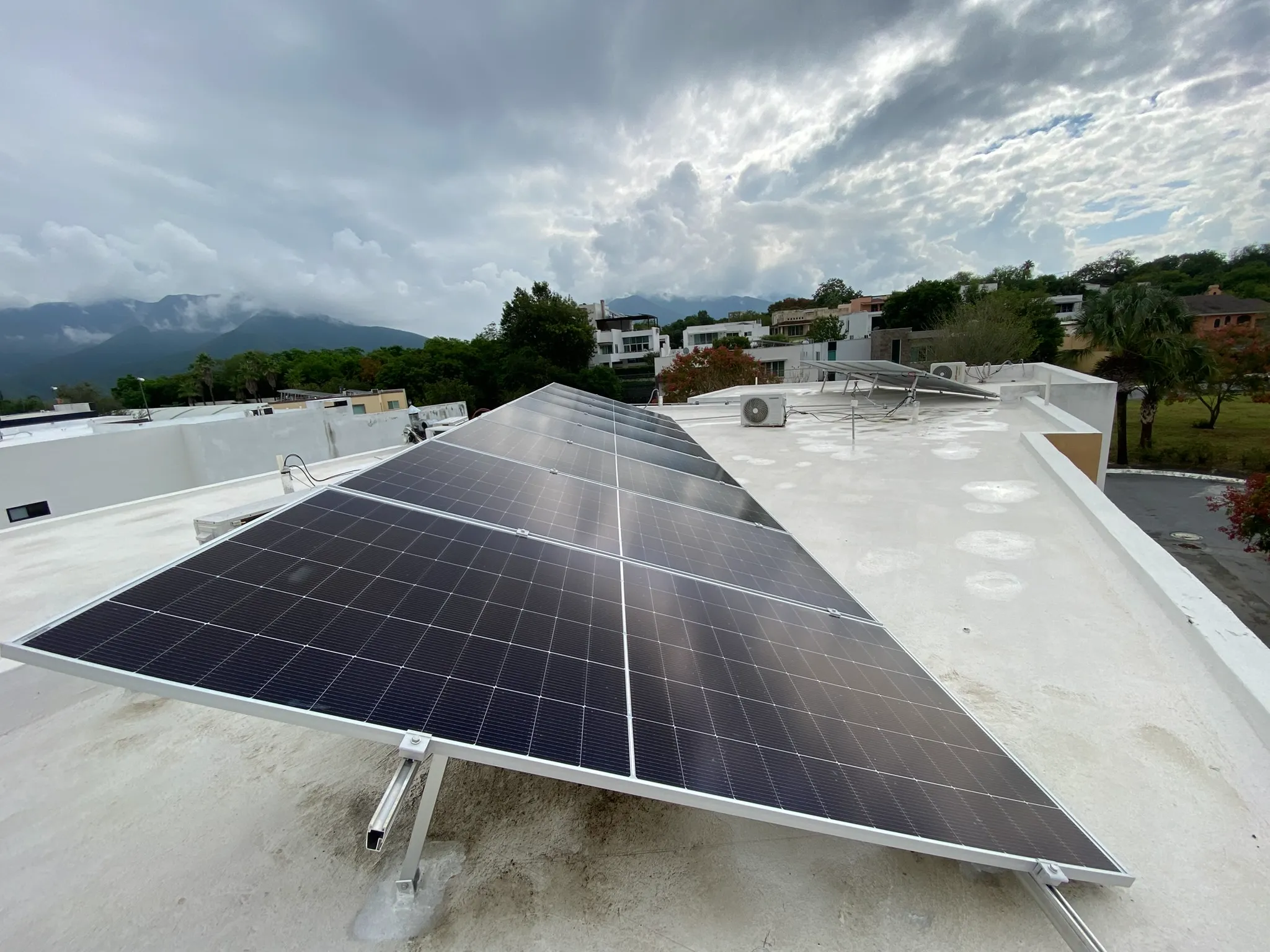Sistema de paneles solares instalado en techo residencial en Santiago con vista a las montañas.
