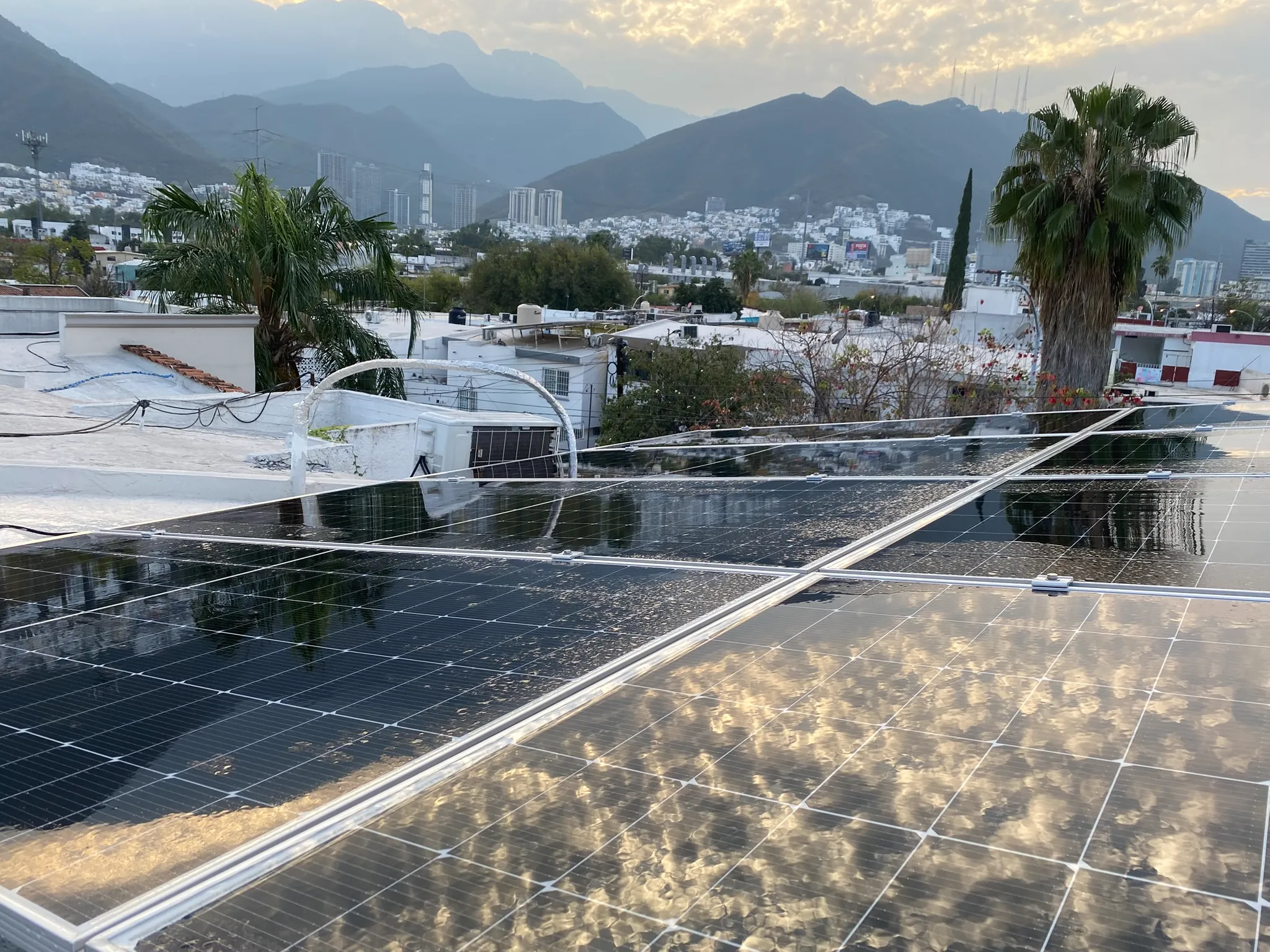 Paneles solares residenciales instalados en Monterrey con vista a la Sierra Madre al atardecer.