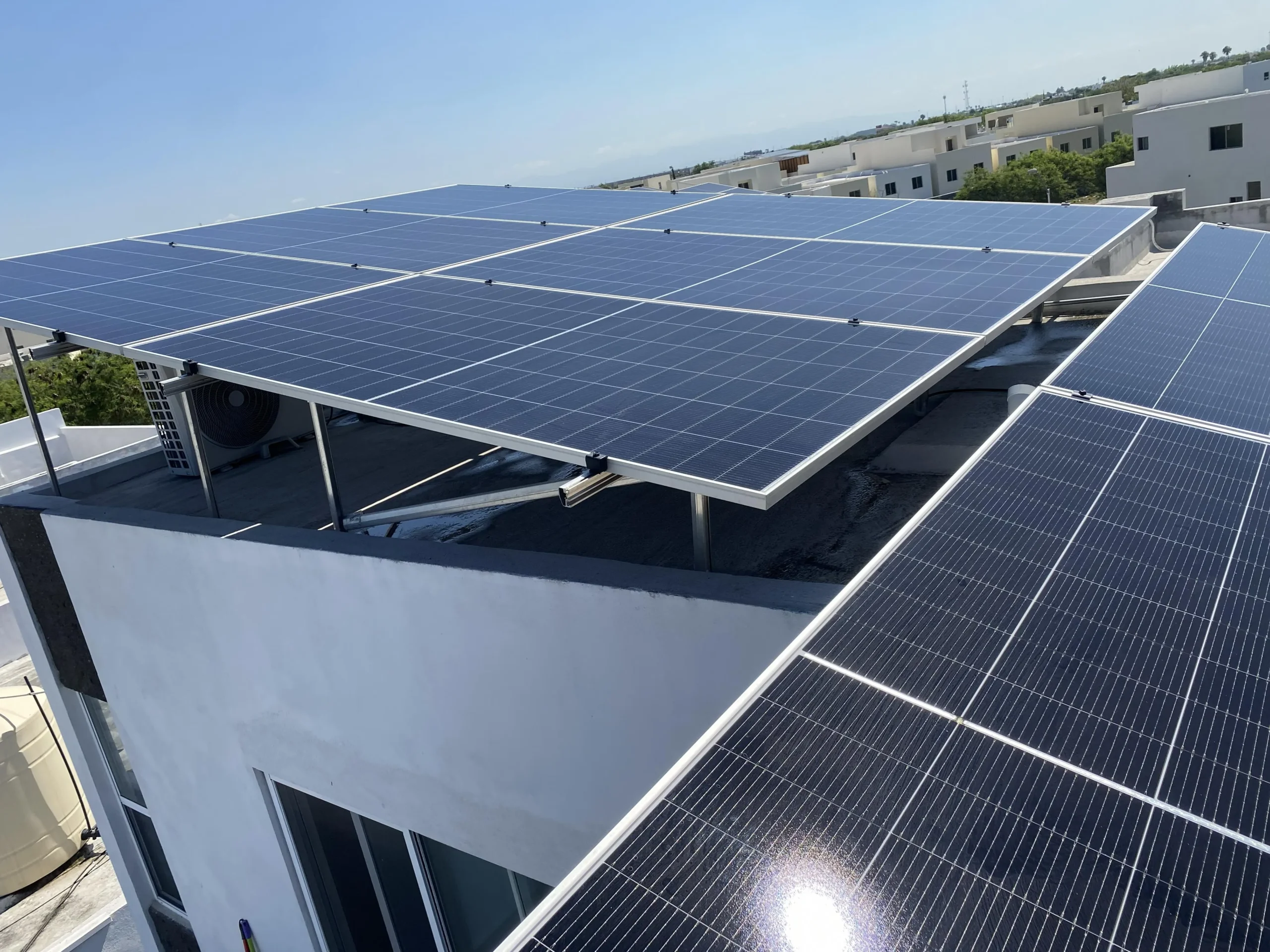 Sistema de paneles solares instalado en techo residencial en Santiago con vista a las montañas.